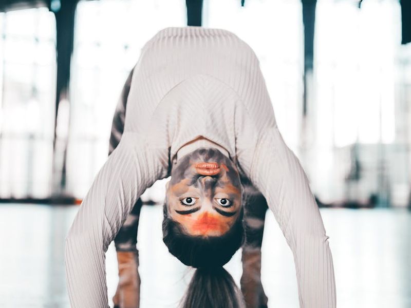 Person performing a smooth yoga transition in a bright studio.