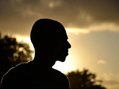 Silhouette of a person in a balance pose against light.